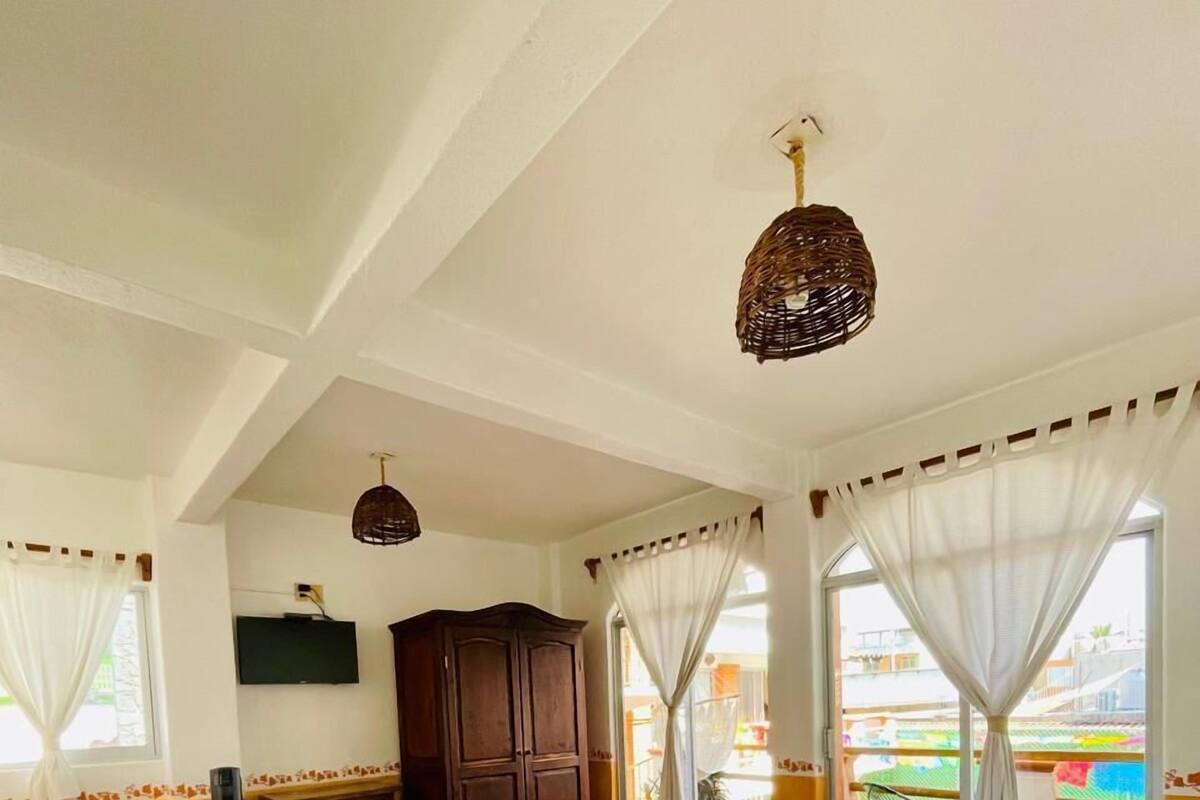 Habitación de hotel con dos camas, un escritorio, un televisor y vistas al exterior.