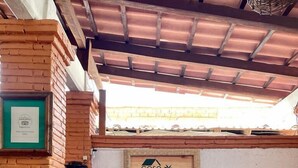 A wooden reception desk with a sign that reads "casa de palma" in a rustic setting with exposed brick walls and a tiled floor. - Hotel Casa de la Palma Bed and Breakfast (Zihuatanejo)