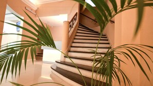 A staircase with a handrail and a light fixture above it. - Acqua Hotel (Mar del Plata)