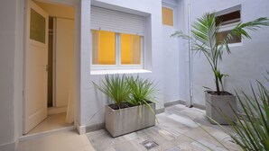 A narrow hallway with a window, a door, and a potted plant. - Acqua Hotel (Mar del Plata)