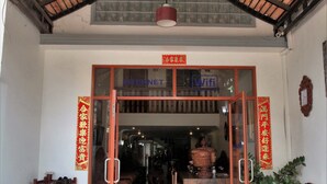 A hotel entrance with a tiled floor, a glass door, and a ceiling with a bamboo design. - Angkor Udom Guesthouse (Siem Reap)