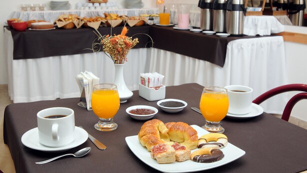 A breakfast table with coffee, juice, croissants, and pastries. - Hotel Salerno (Villa Carlos Paz)