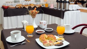 A breakfast table with coffee, juice, croissants, and pastries. - Hotel Salerno (Villa Carlos Paz)