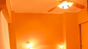 A hotel room with a bed, a nightstand, a wall-mounted light, and a ceiling fan. - Hotel Castelmar (Mar del Plata)