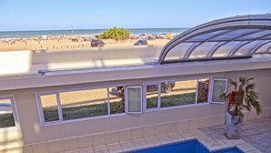 Una piscina con vistas a una playa y coches estacionados.