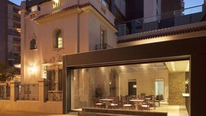 A modern building with a dining area visible through large glass windows. - Ambit Boulevard Hotel Boutique (Santa Fe)