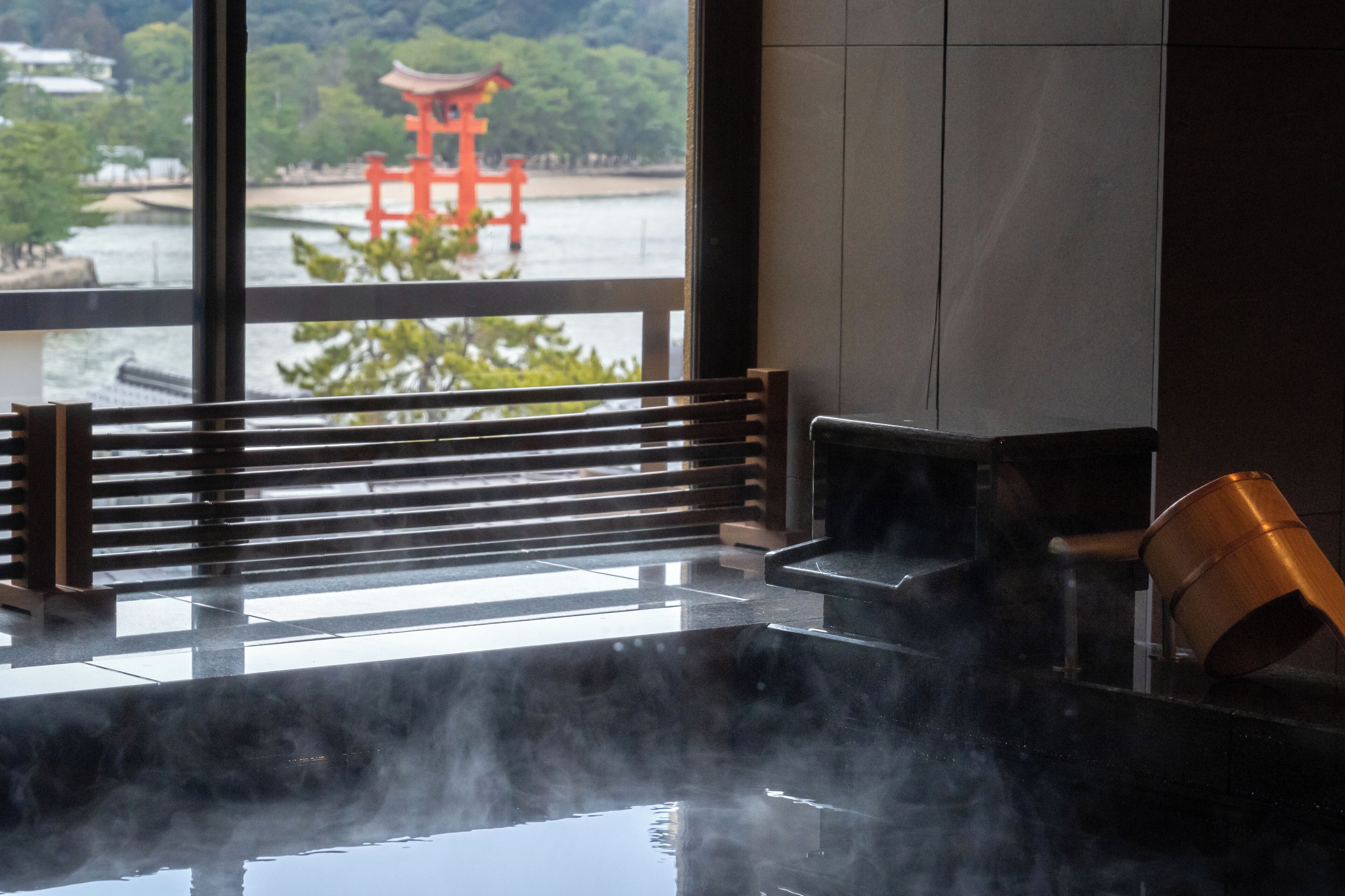 Een warmwaterbrongebied met een houten bank en een traditionele Japanse waterkruik.