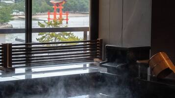 Een warmwaterbrongebied met een houten bank en een traditionele Japanse waterkruik.