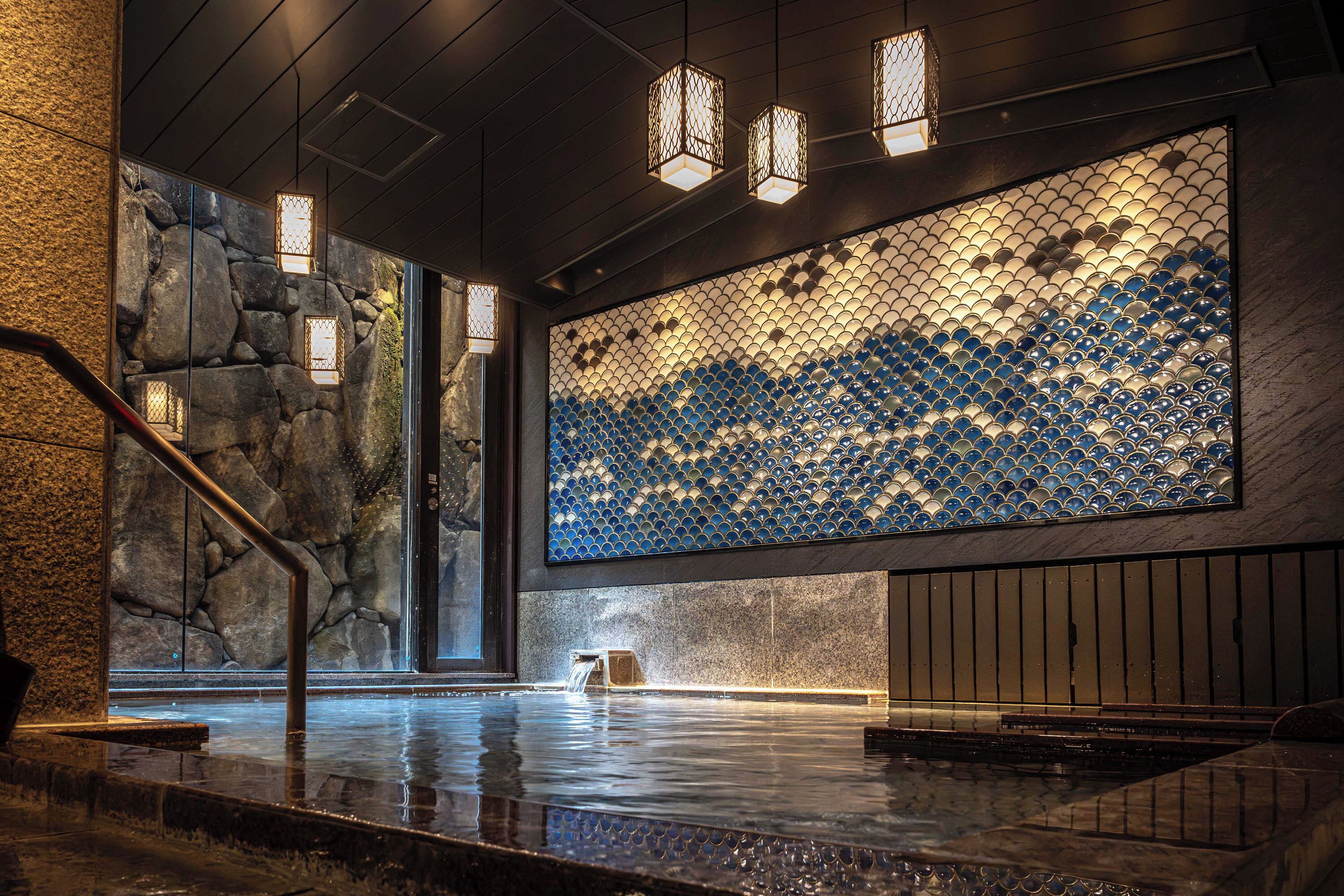 A modern interior with a stone wall, a water feature, and a patterned wall.