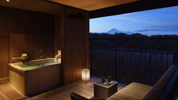 A modern bathroom with a wooden bathtub and a glass-enclosed shower area.