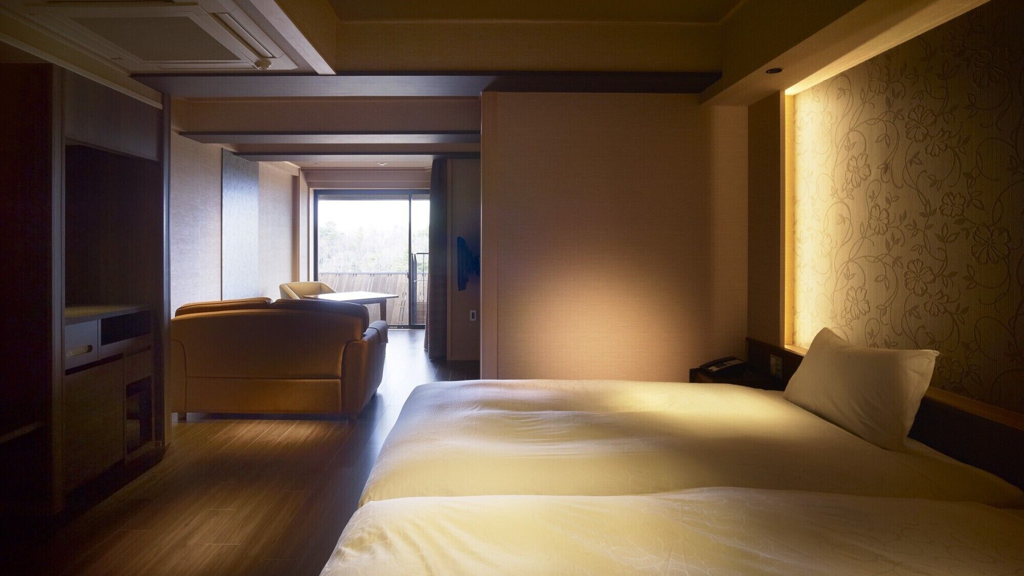 Une chambre d’hôtel avec un lit, un canapé, un bureau et une vue sur l’extérieur.