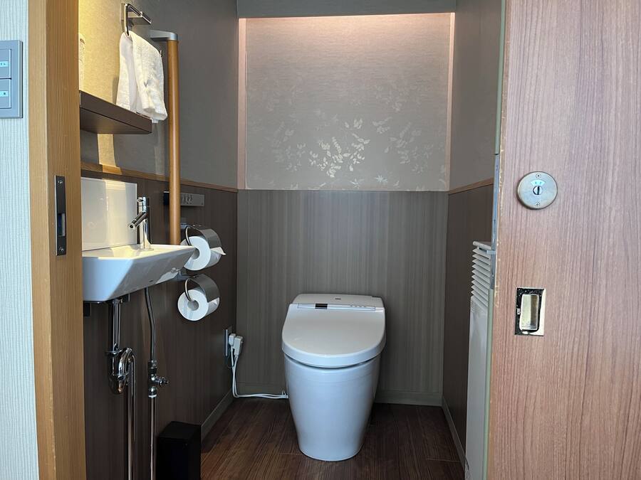 Ein kleines Badezimmer mit Toilette, Waschbecken und Handtuchhalter.