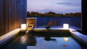A serene indoor pool area with a view of a mountain at dusk.
