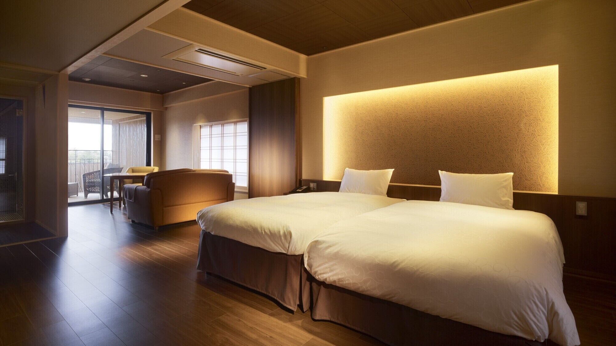 Une chambre d’hôtel dotée d’un grand lit, d’un canapé, d’un coin repas et offrant une vue sur l’extérieur.