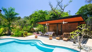 A modern house with a swimming pool, wooden deck, and outdoor furniture. - Green Bamboo Cabana (Roatan)