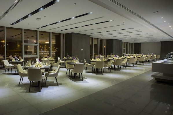 A modern dining area with tables and chairs arranged for guests.