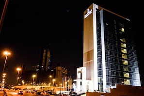 A modern hotel with a prominent vertical structure and a glass facade.