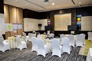 A conference room with round tables, white chairs, and a projector screen. - Executives Hotel Kafd (Riyadh)