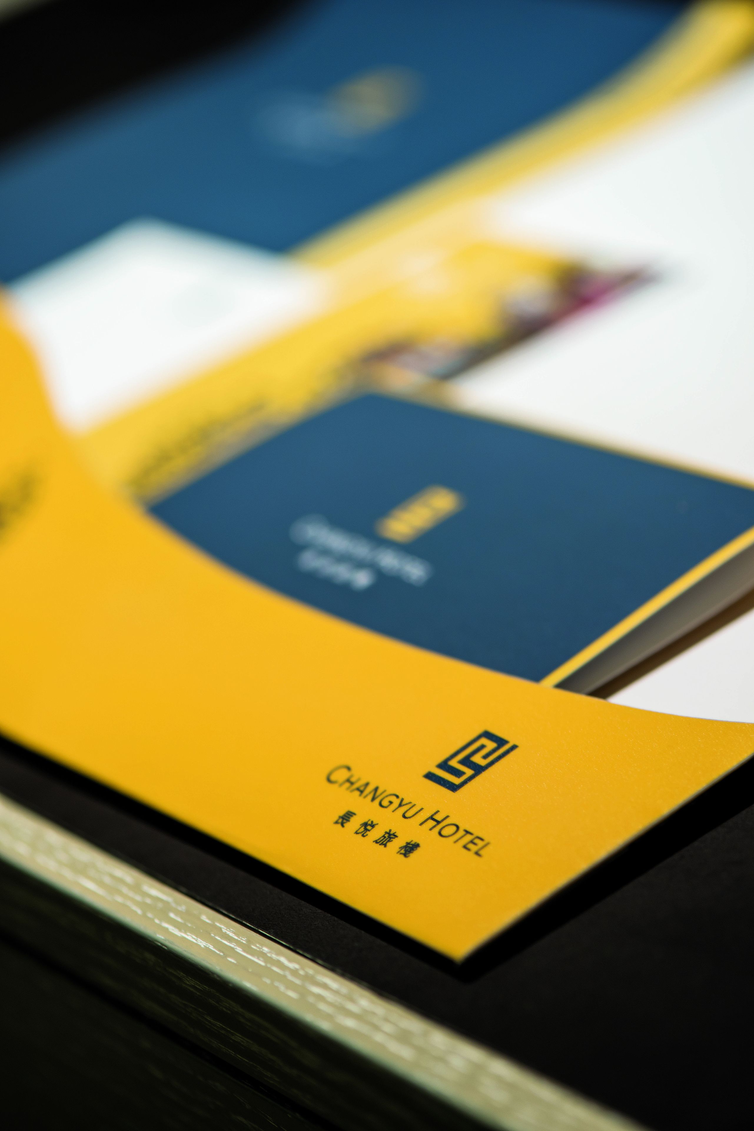 A close-up of a yellow and blue brochure with the text "CHANGYU HOTEL" and some Chinese characters.