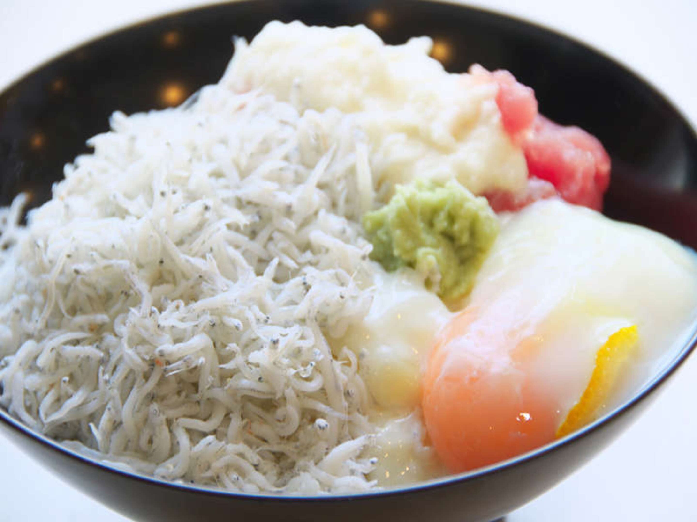 A bowl of rice, avocado, and a poached egg.