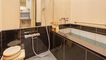 A modern bathroom with a bathtub, a shower, and a toilet.