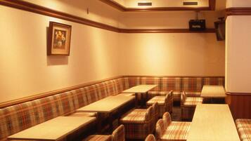 A conference room with plaid-patterned seating, a projector, and a framed picture on the wall.