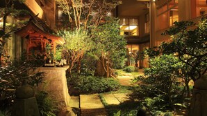 A courtyard with traditional Japanese architecture, including a torii gate and stone lanterns. - Jyoseikan (Kochi)