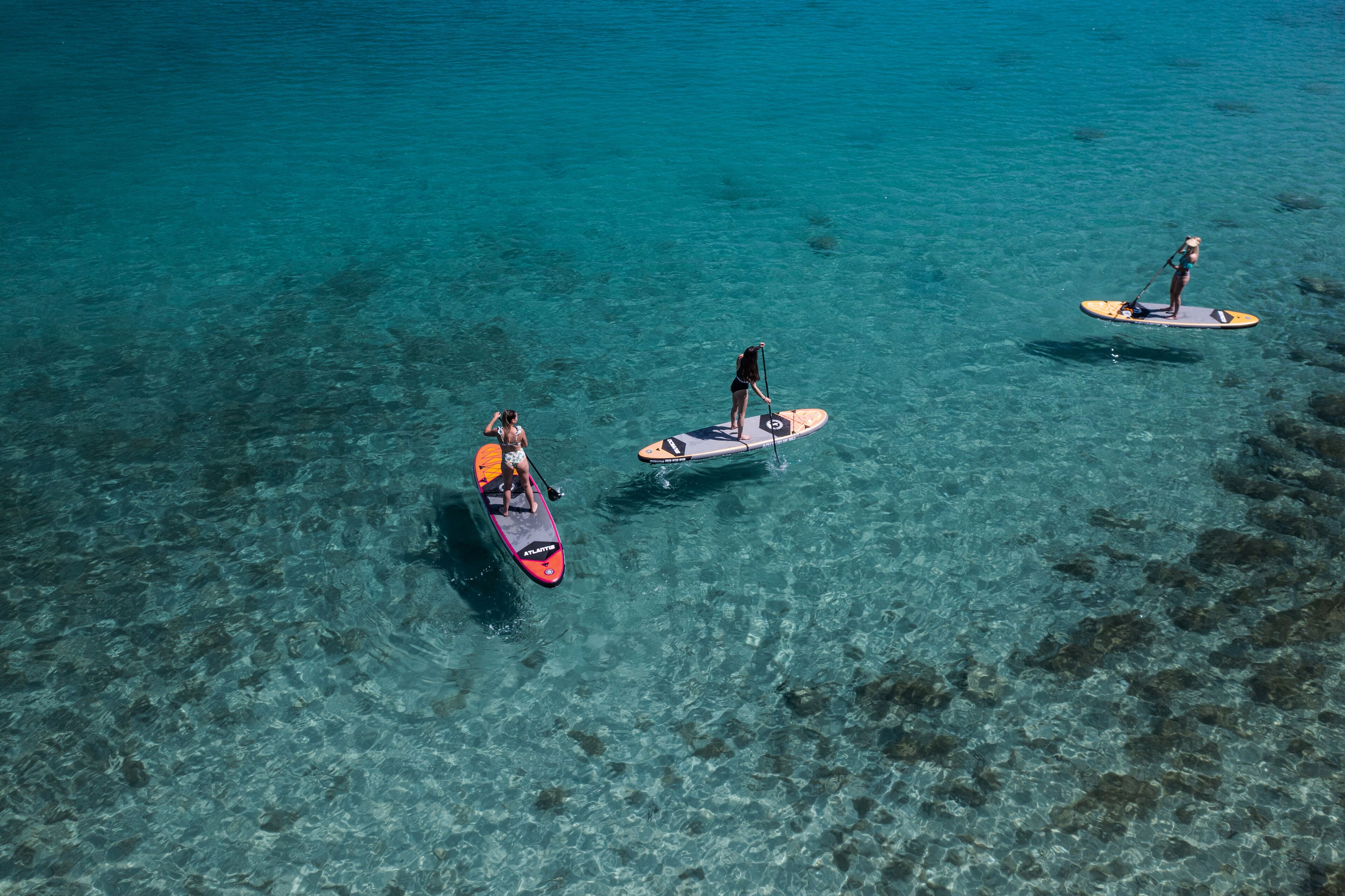 Three paddleboards on clear turquoise water.