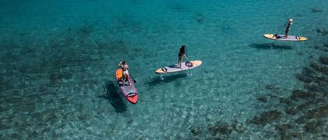 Three paddleboards on clear turquoise water.