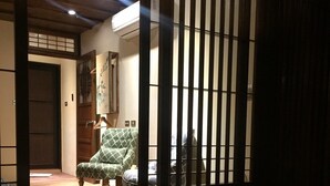 A traditional Japanese room with tatami flooring, a low wooden table, and a green patterned sofa. - Sunshiny Castle (Tainan)