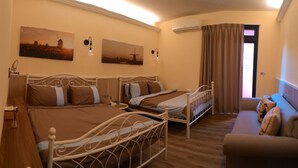 A hotel room with two beds, a sofa, and two wall-mounted lamps. - Sunshiny Castle (Tainan)