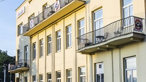 A multi-story building with balconies, large windows, and a flat facade. - Penzión Sport (Kosice)
