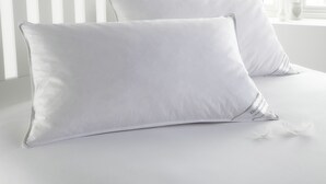 Two white pillows on a bed with a white headboard and a window in the background. - Victoria Hotels Royal Garden (Como)