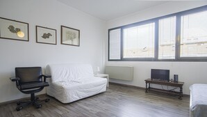 A room with a bed, a desk with a computer, a chair, and large windows with blinds. - Victoria Hotels Royal Garden (Como)