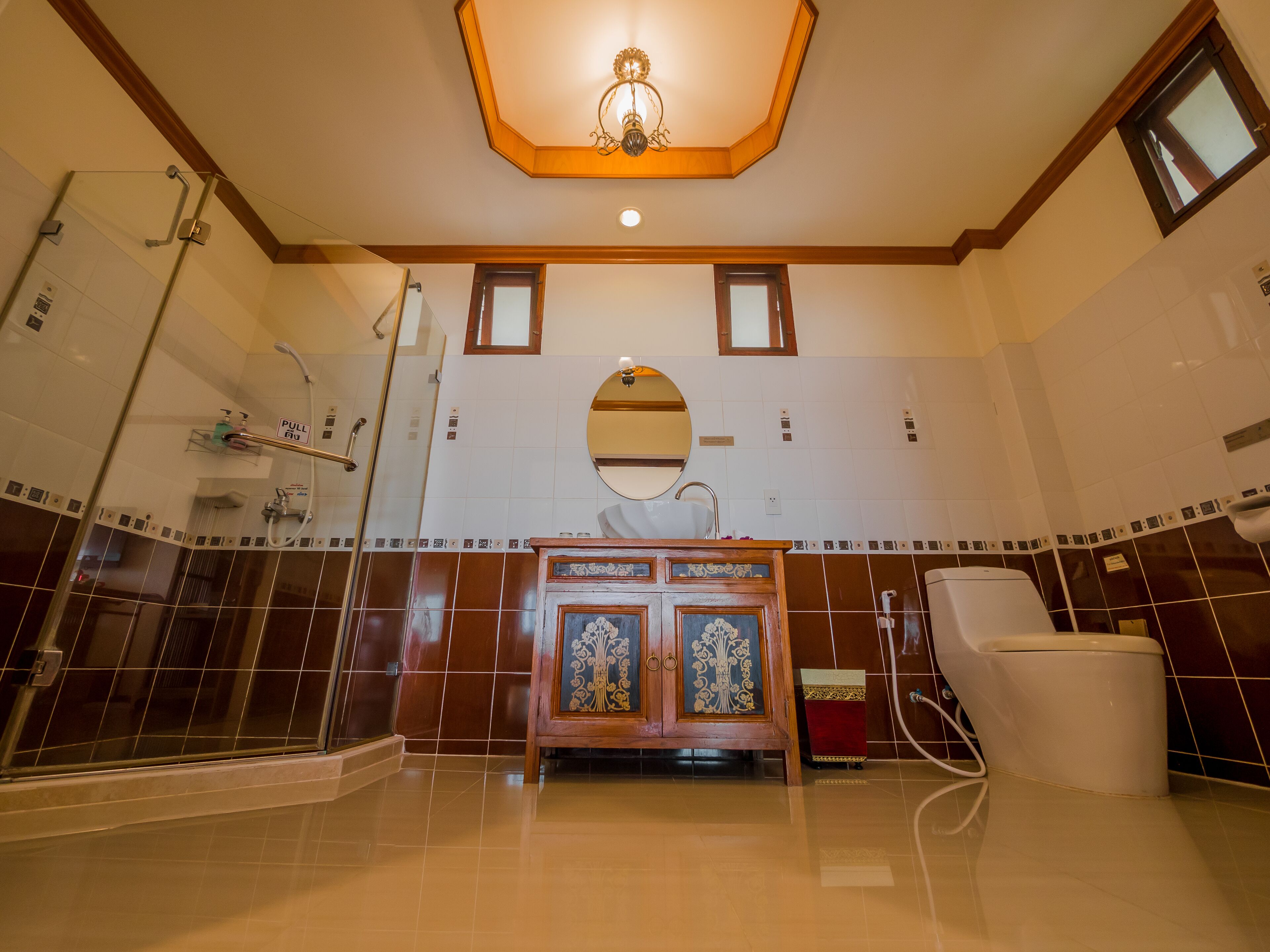 A bathroom with a shower, a sink with a mirror, and a toilet.