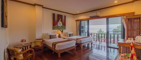 A hotel room with two beds, a balcony with a view, and a wooden floor.