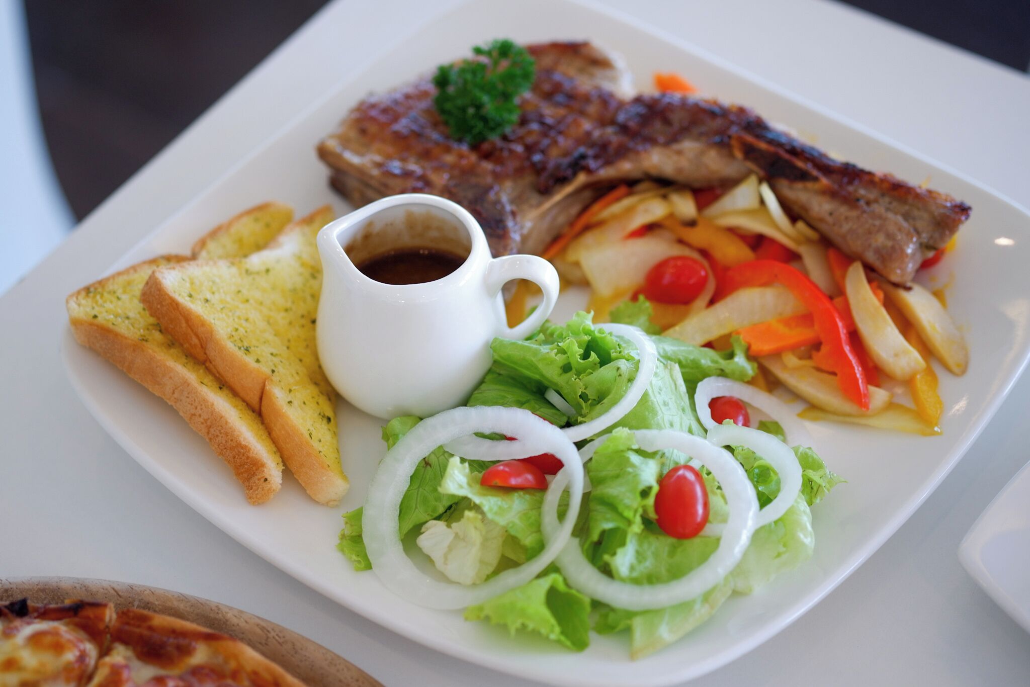 A plate of food including steak, fries, salad, and toast.