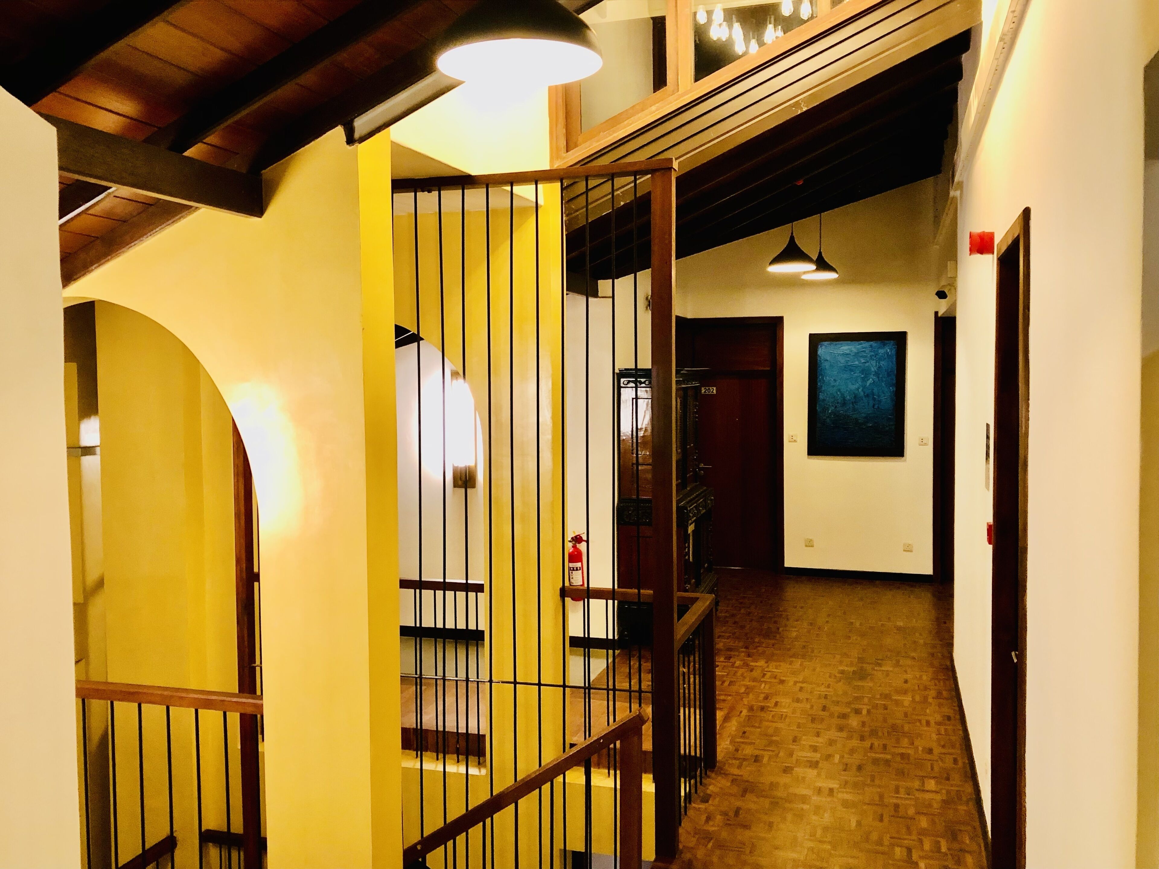 A staircase with wooden railings and a yellow wall.