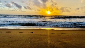 Una playa con olas y un atardecer.