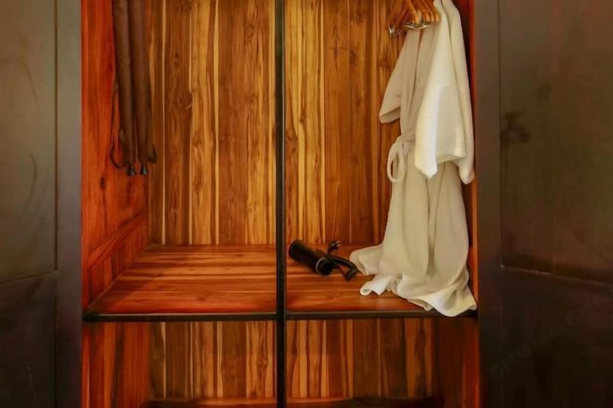 Un armario de madera con barra para colgar y estante.