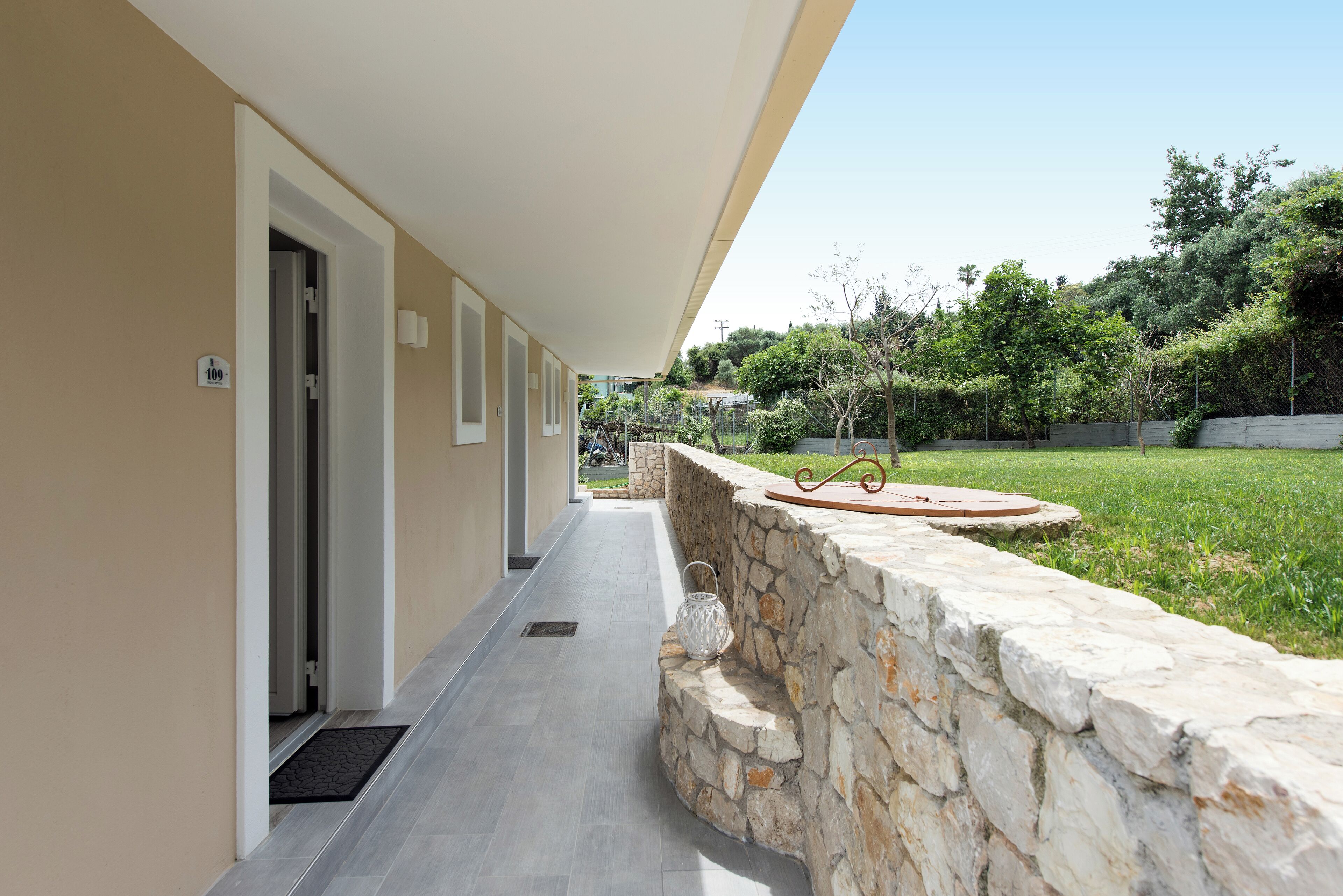 A corridor with a stone wall, a door, and a number sign.