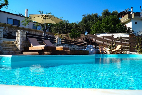 Una piscina al aire libre de temporada, sombrillas, tumbonas