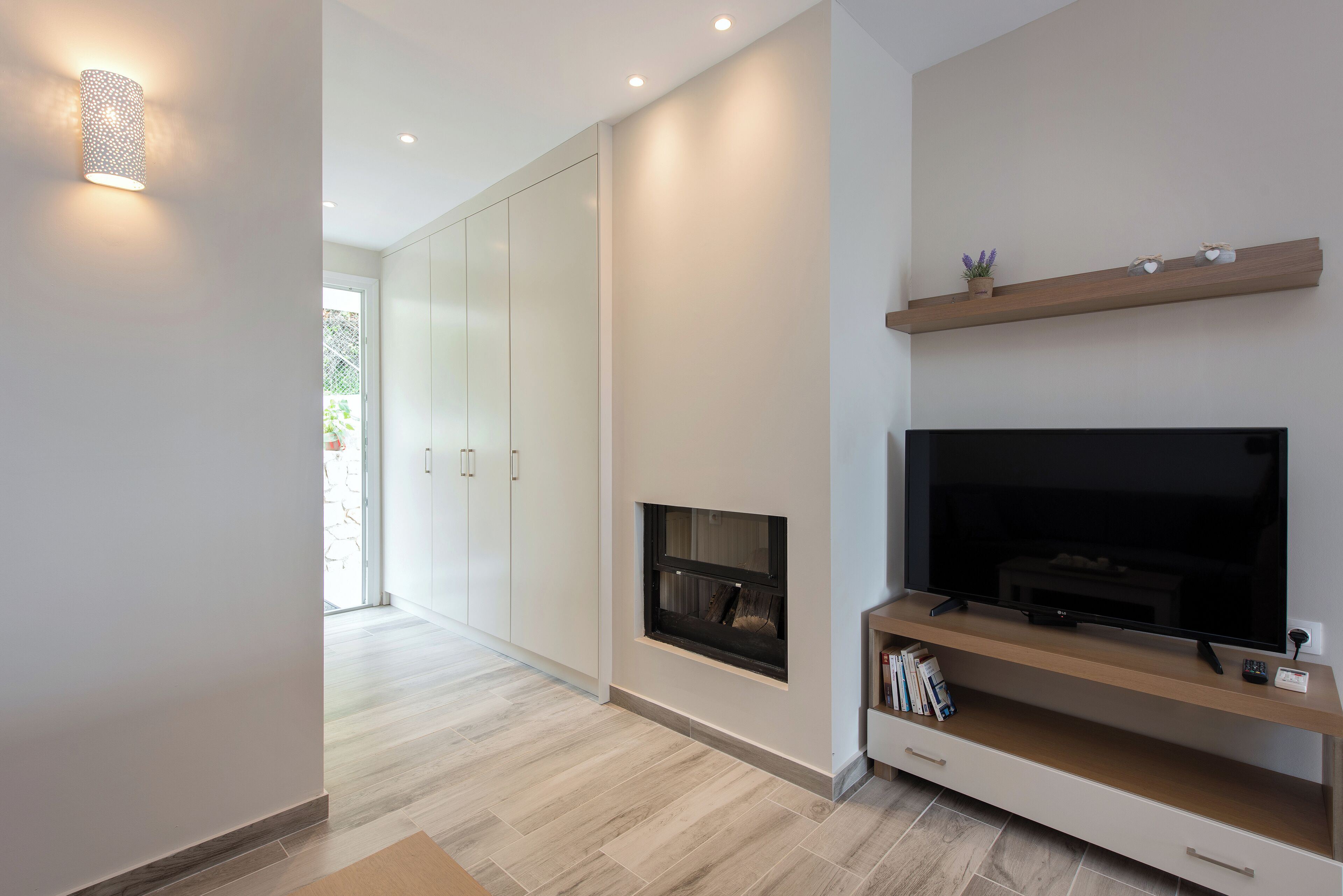 Una sala moderna con chimenea, televisor empotrado y decoración minimalista.