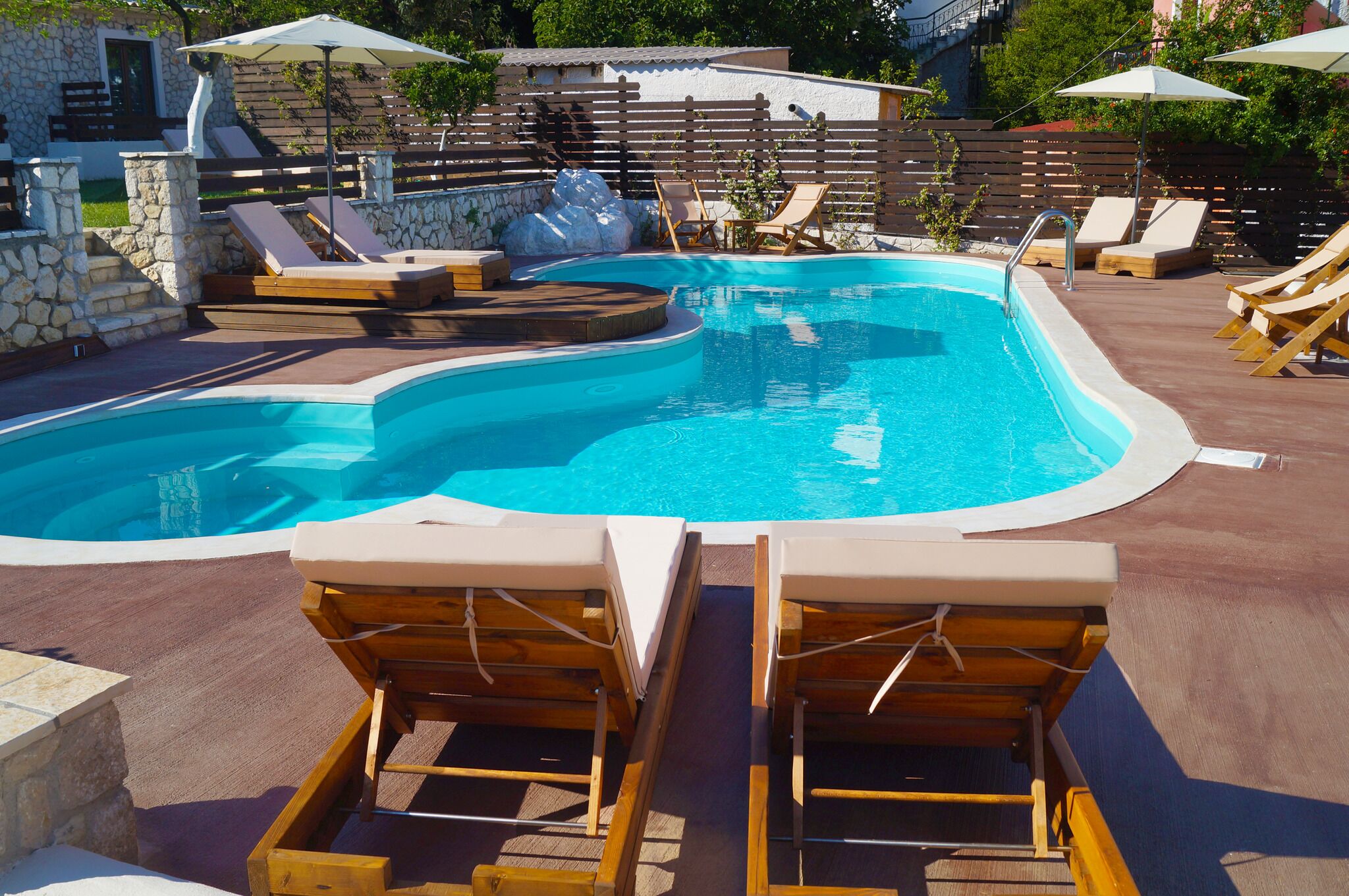 Una piscina con sillas de descanso y sombrillas.