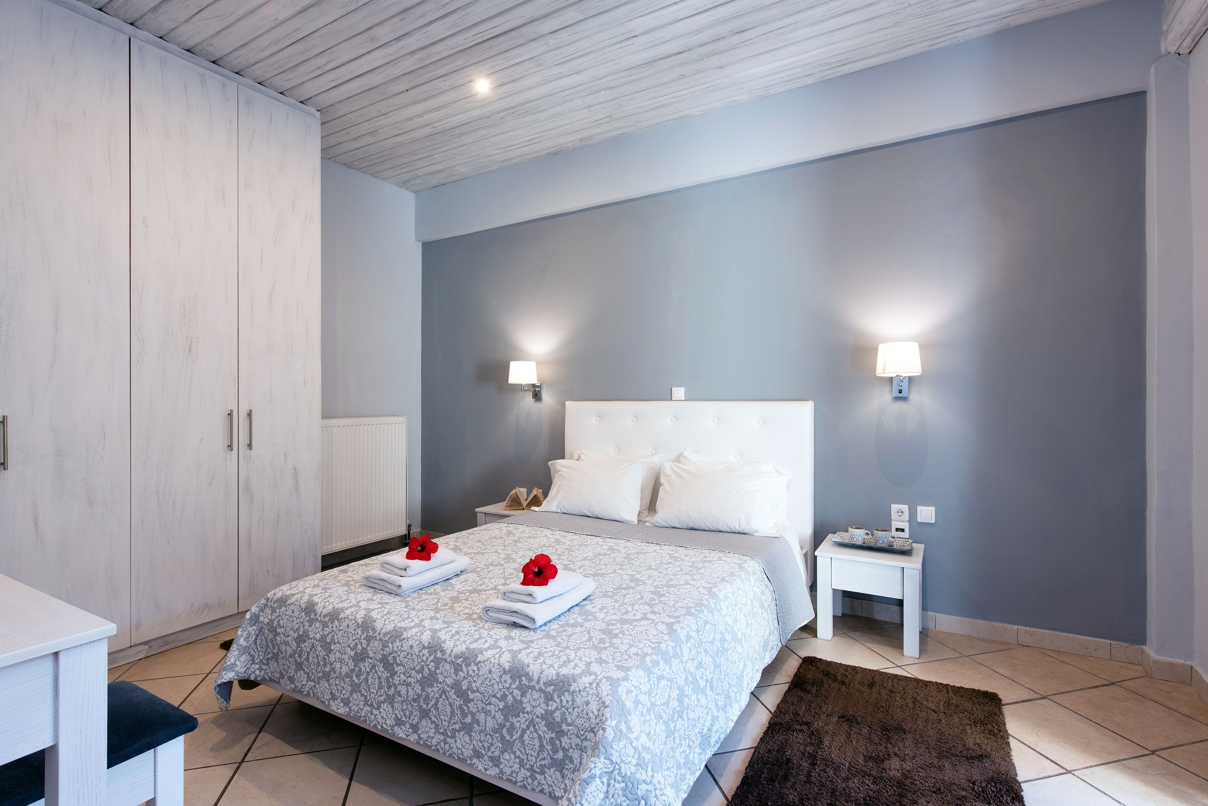 A bedroom with a bed, bedside tables, a wardrobe, and a nightstand.