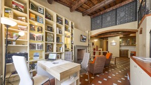 Un rincón acogedor para leer, con estanterías, chimenea y asientos cómodos.