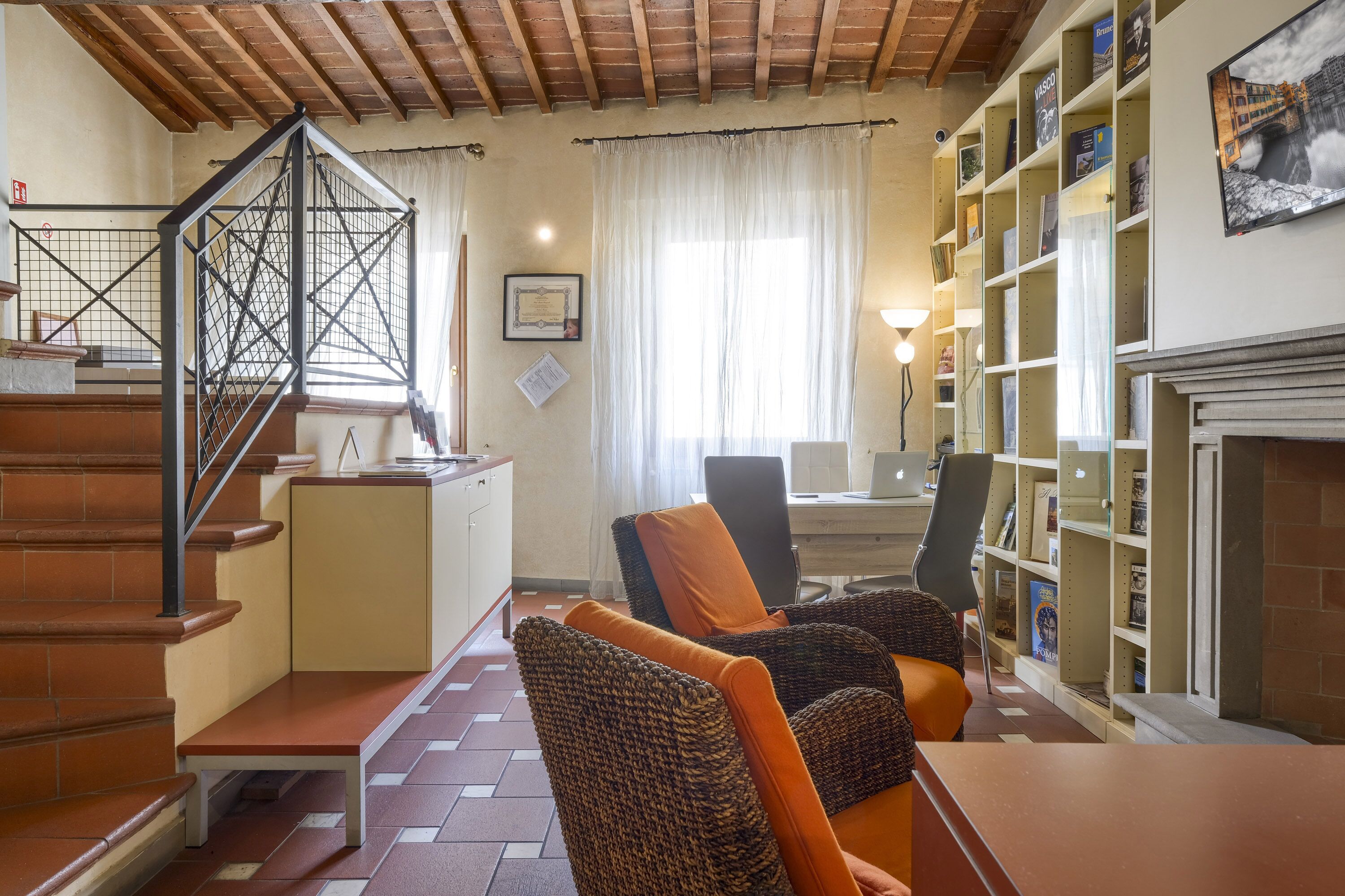 Ein gemütliches Wohnzimmer mit Kamin, Bücherregal und Wendeltreppe.