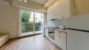 Una cocina moderna con horno integrado, refrigerador y pileta.