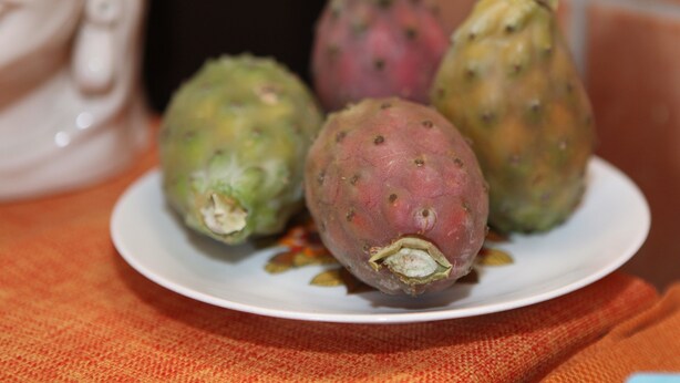 Un plato con varias frutas sobre un mantel.