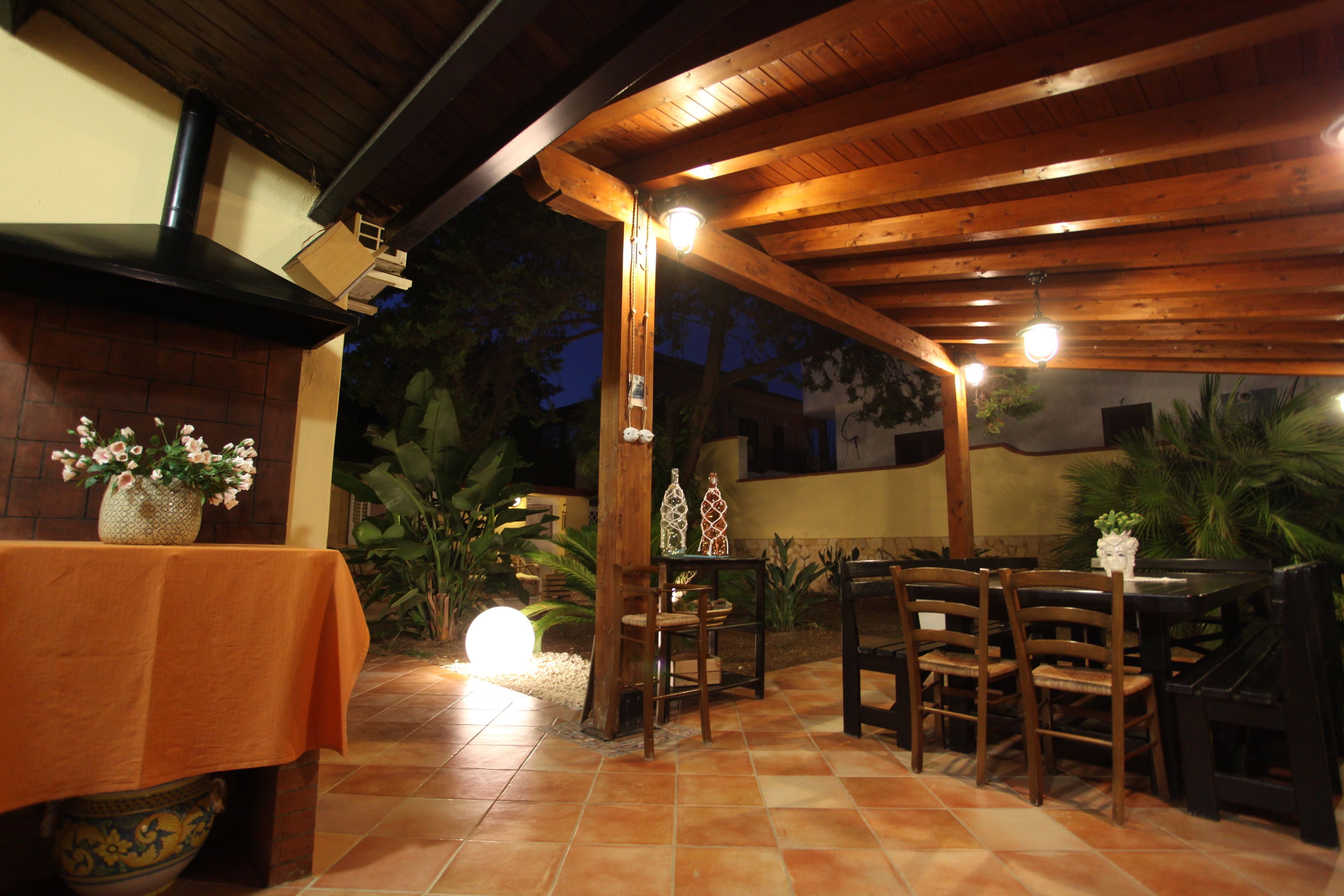 Une terrasse extérieure avec des meubles en bois et un sol carrelé.